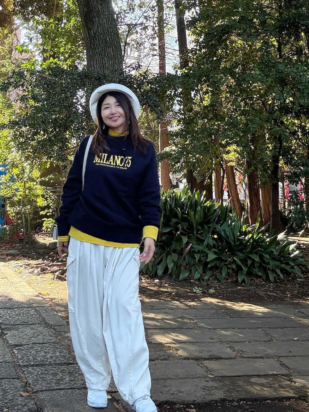 ホワイト系のトートバッグ、ホワイト系のカーゴパンツ、ホワイト系のスニーカーを着用したレディースの春コーディネートの2枚目の写真