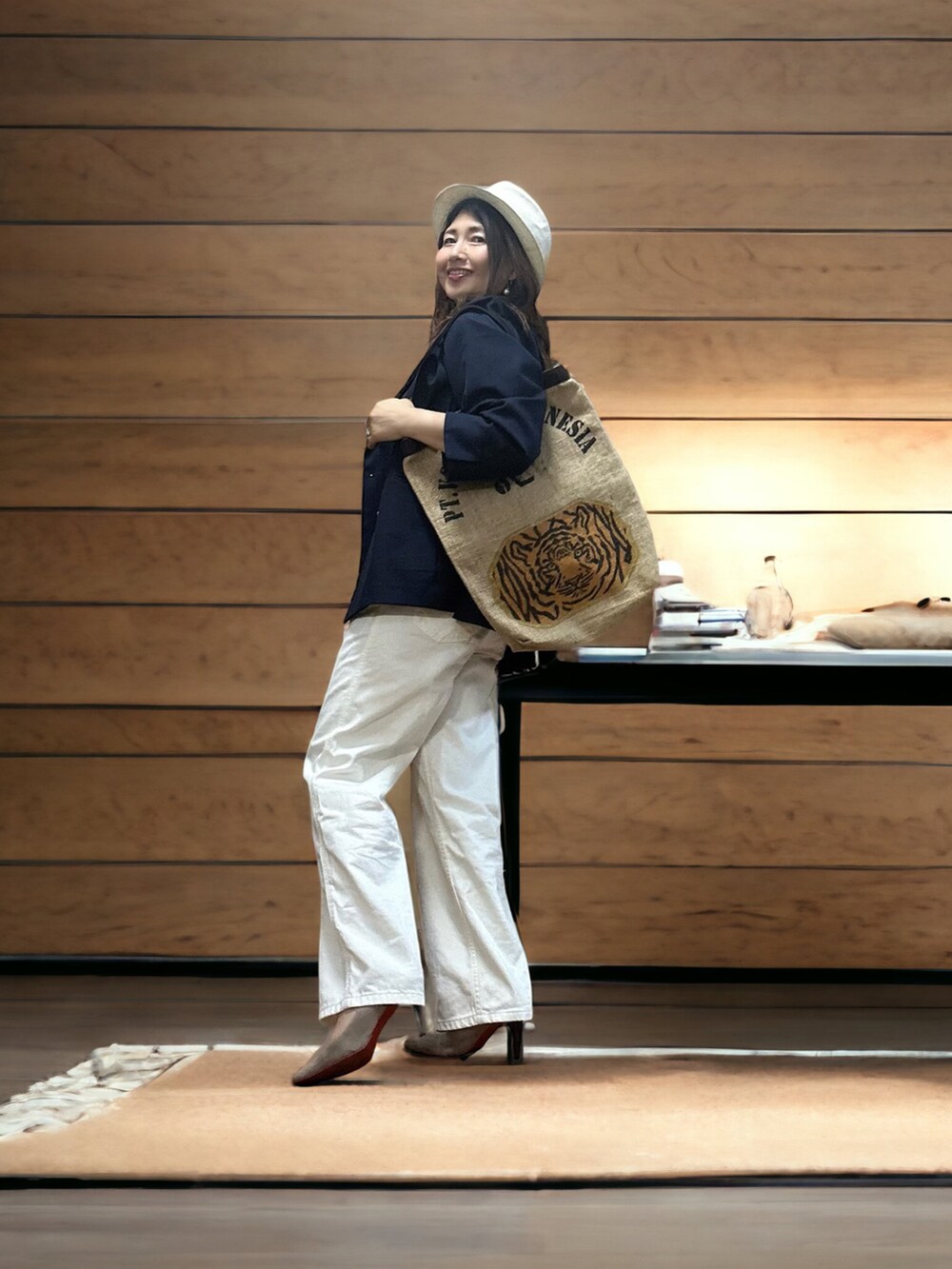 ブルー系のテーラードジャケット、ベージュ系のトートバッグ、ホワイト系のデニムパンツを着用したレディースの秋コーディネートの4枚目の写真