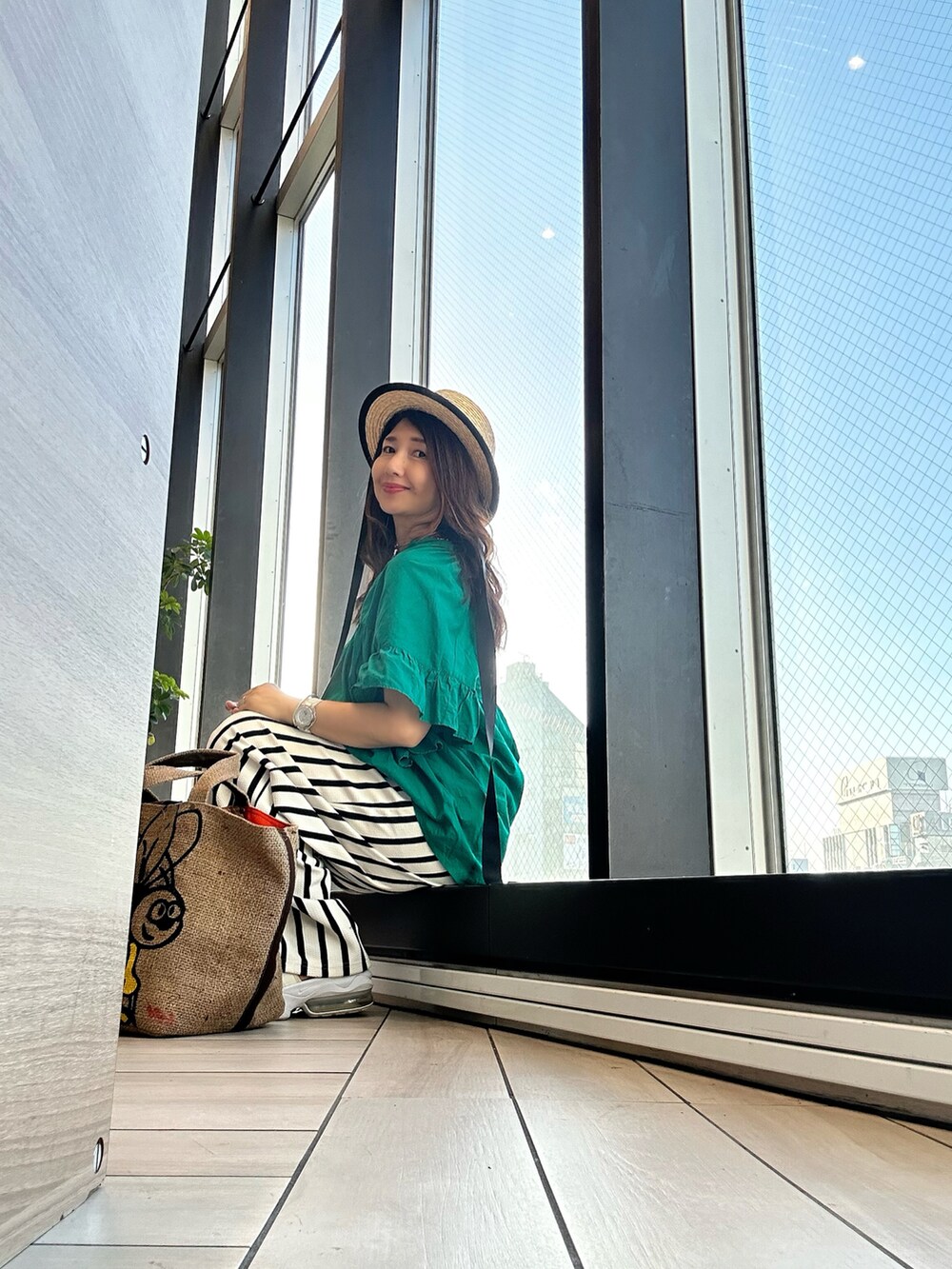 グリーン系のシャツ/ブラウス、ホワイト系のその他パンツ、ベージュ系のトートバッグを着用したレディースの夏コーディネートの4枚目の写真