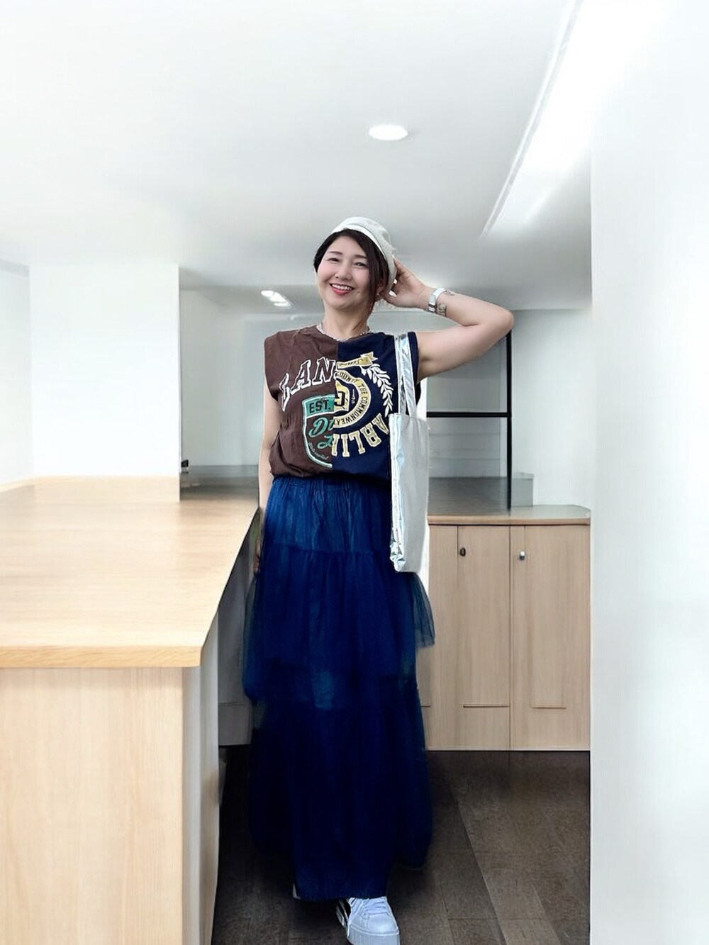 ホワイト系のスニーカー、グレー系のTシャツ/カットソー、ブルー系のデニムパンツを着用したレディースの秋コーディネートの5枚目の写真