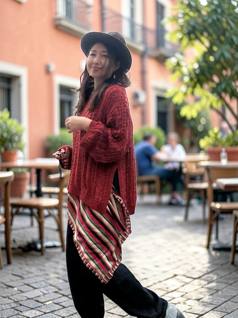 ホワイト系のタンクトップ、レッド系のニット/セーター、ブルー系のデニムパンツを着用したレディースの春コーディネートの2枚目の写真