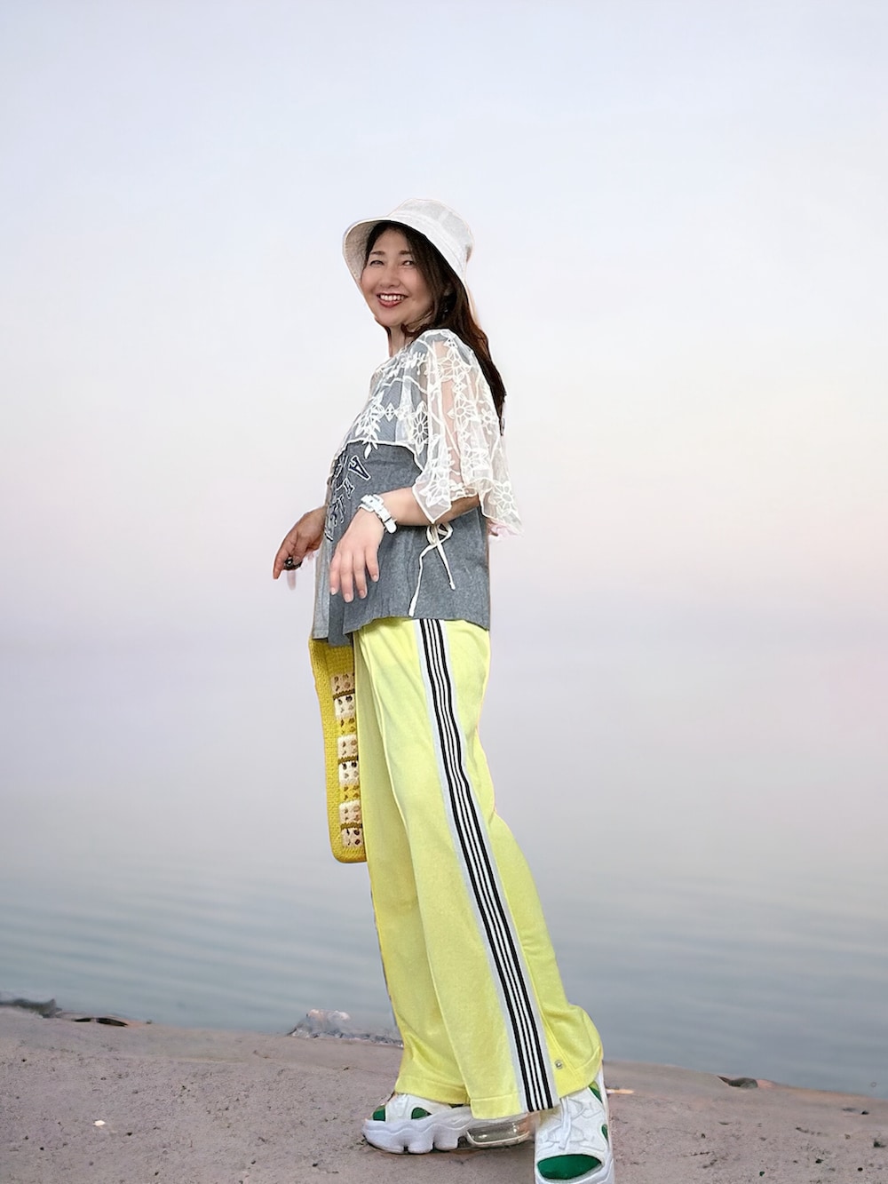 イエロー系のその他パンツ、ホワイト系のサンダル、グレー系のTシャツ/カットソーを着用したレディースの春コーディネートの4枚目の写真