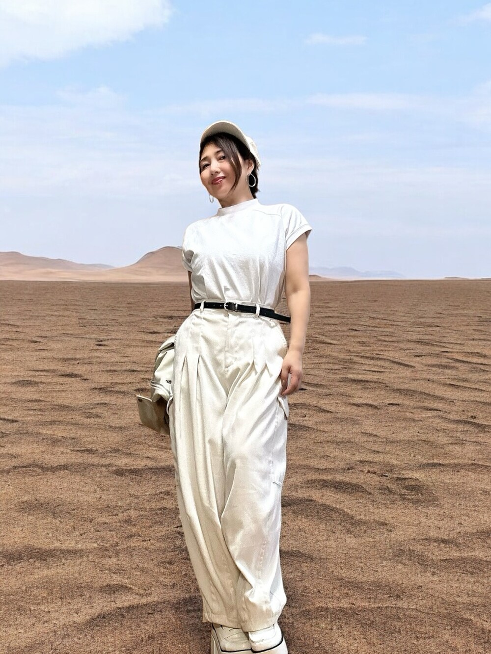 ホワイト系のカーゴパンツ、ホワイト系のTシャツ/カットソー、ホワイト系のライダースジャケットを着用したレディースの秋コーディネートの2枚目の写真