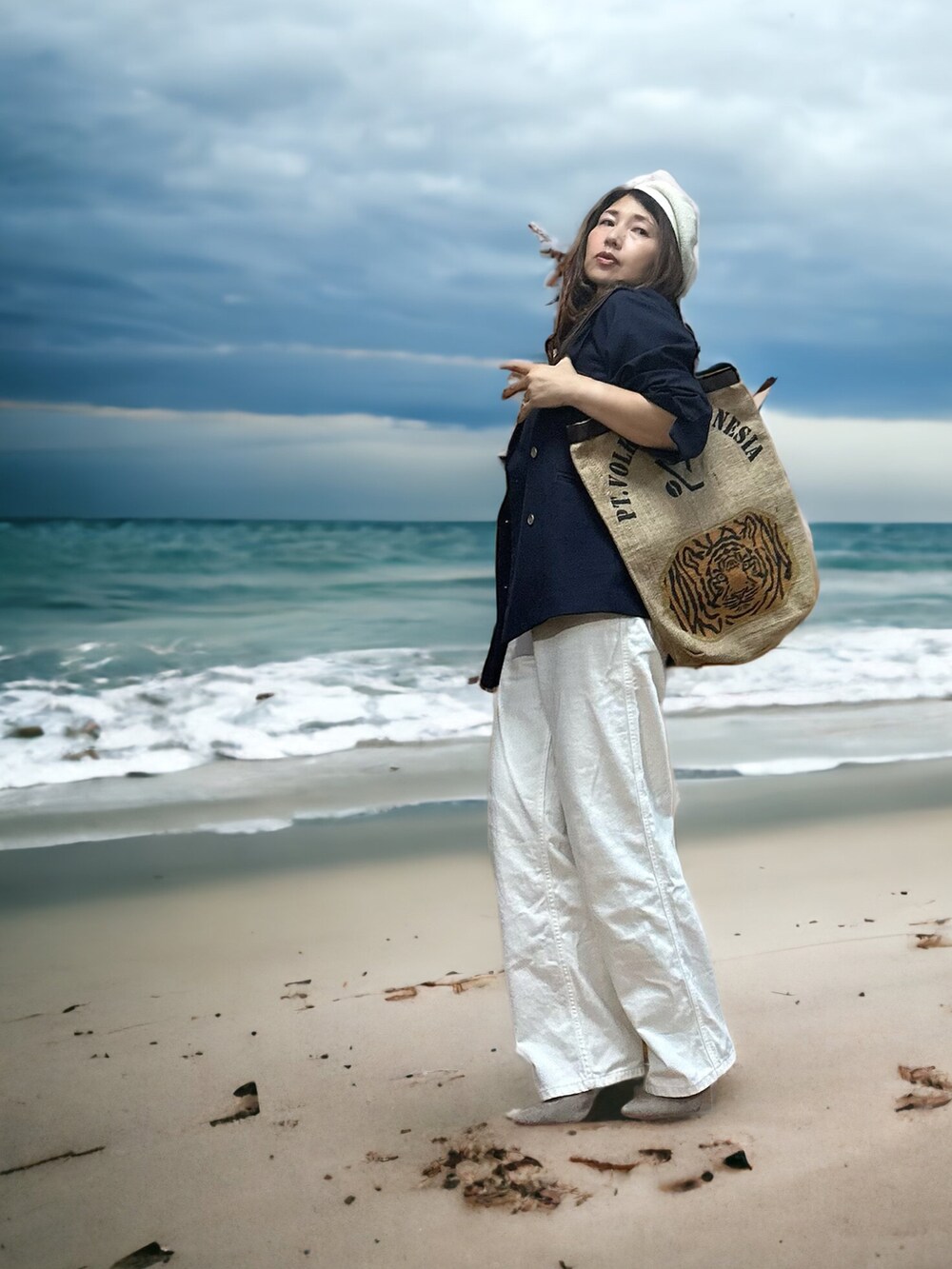 ブルー系のテーラードジャケット、ベージュ系のトートバッグ、ホワイト系のデニムパンツを着用したレディースの秋コーディネートの2枚目の写真