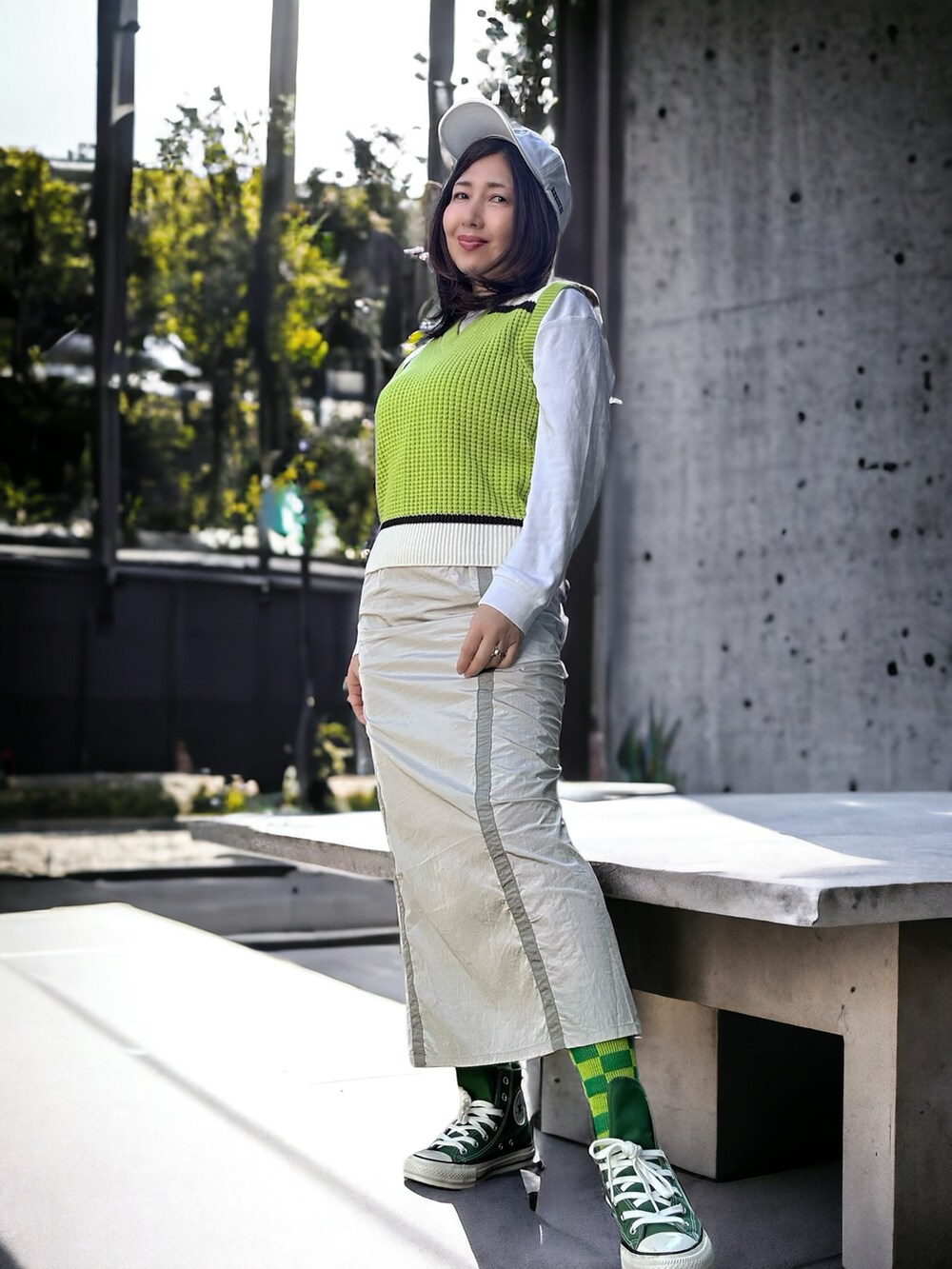 グリーン系のベスト、グレー系のスカート、ホワイト系のチュニックを着用したレディースの春コーディネートの4枚目の写真