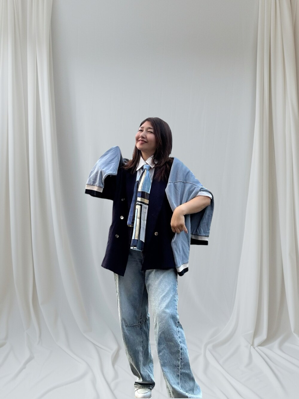 ブルー系のテーラードジャケット、その他のデニムパンツ、シルバー系のローファーを着用したレディースの秋コーディネートの4枚目の写真