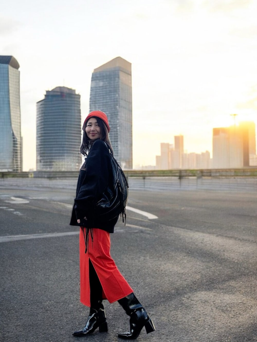 ブラック系のショルダーバッグ、ブラック系のスウェット、オレンジ系のスカートを着用したレディースの冬コーディネートの4枚目の写真