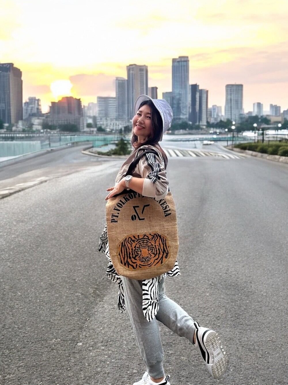 ホワイト系のスニーカー、ベージュ系のトートバッグ、ベージュ系のトップスを着用したレディースの春コーディネートの2枚目の写真