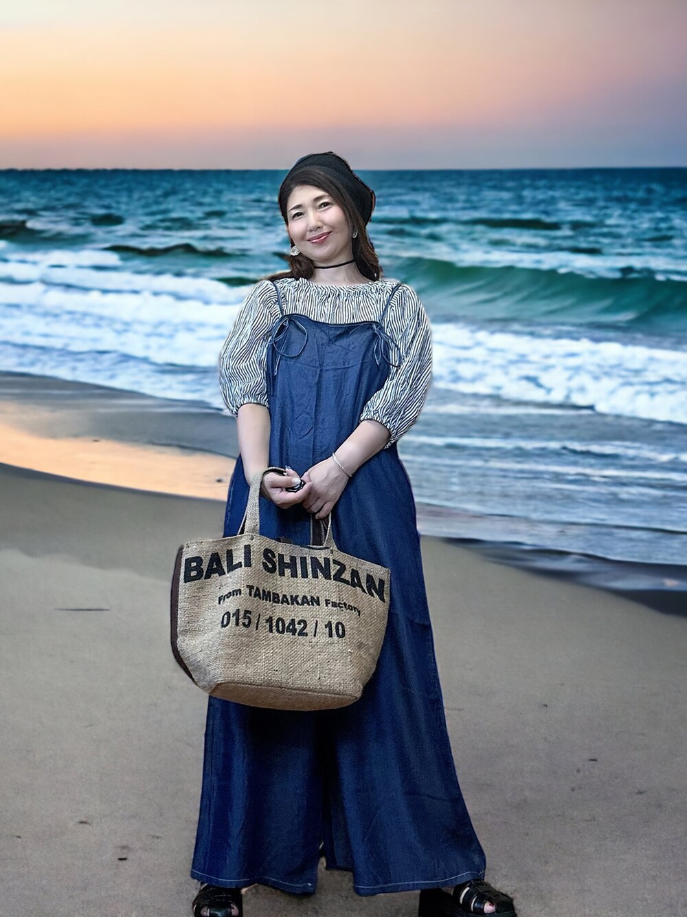 ベージュ系のトートバッグ、ブルー系のサロペット/オーバーオール、ブラック系のシャツ/ブラウスを着用したレディースの秋コーディネートの4枚目の写真