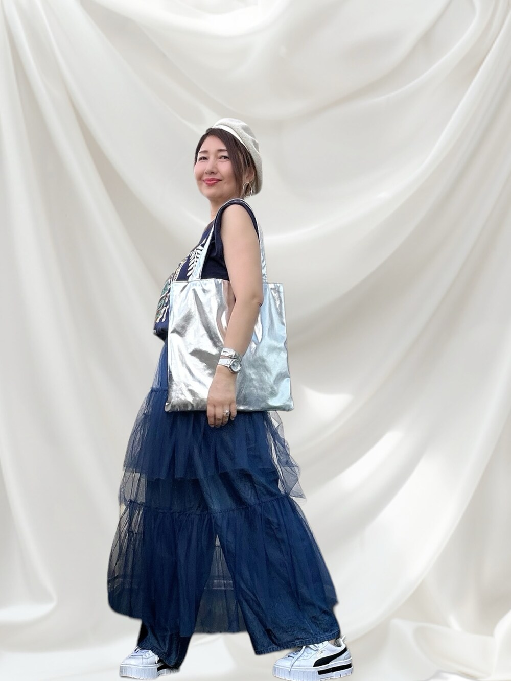 ホワイト系のスニーカー、グレー系のTシャツ/カットソー、ブルー系のデニムパンツを着用したレディースの秋コーディネートの3枚目の写真