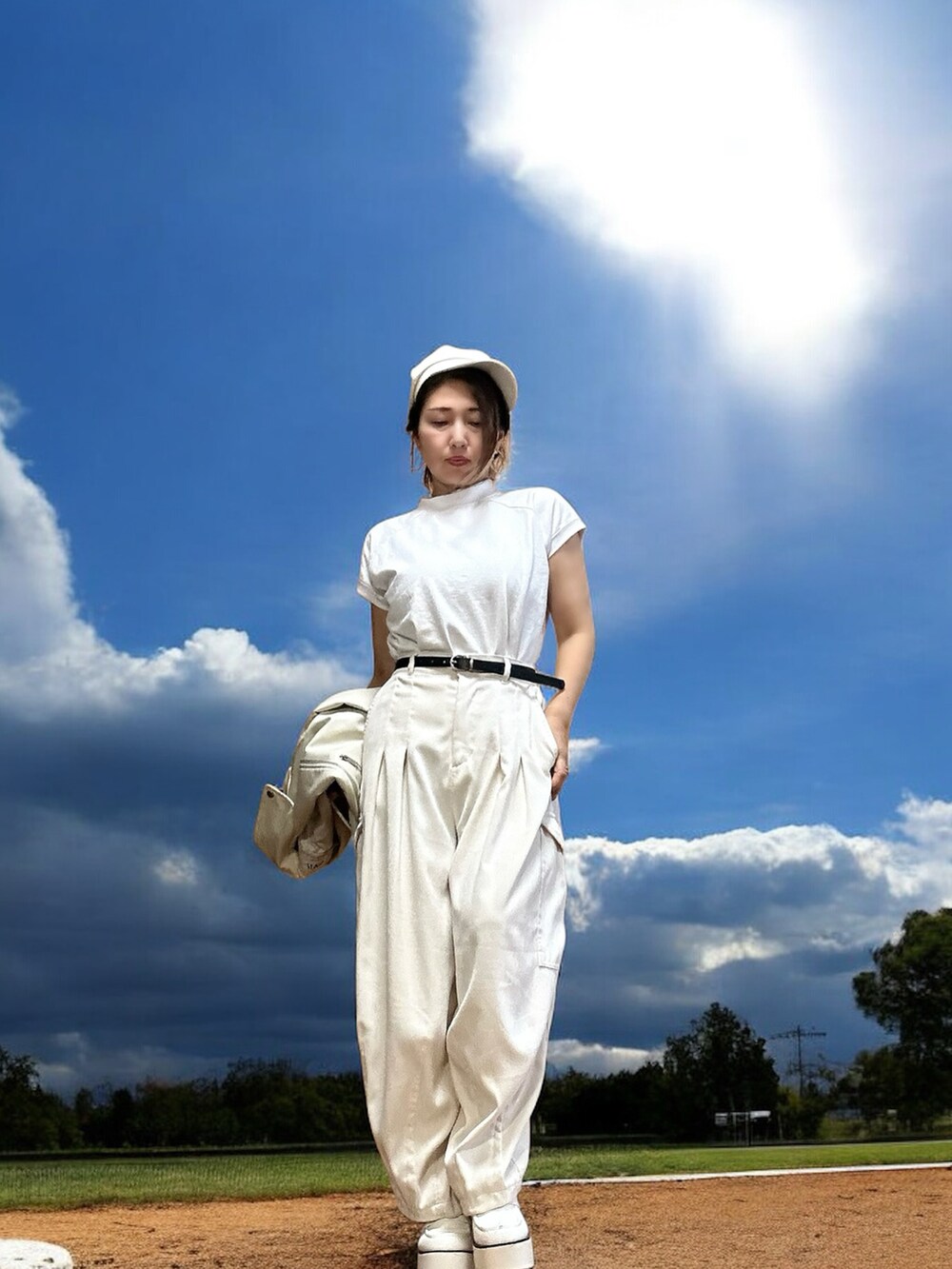 ホワイト系のカーゴパンツ、ホワイト系のTシャツ/カットソー、ホワイト系のライダースジャケットを着用したレディースの秋コーディネートの3枚目の写真