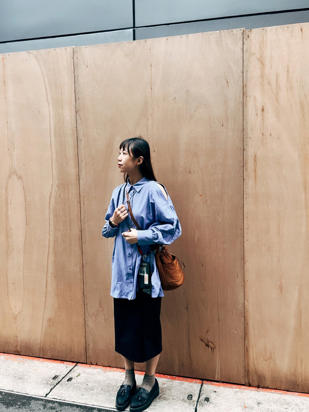 ブルー系のシャツ/ブラウス、ブラック系のスカート、ブラウン系のドラムバッグを着用したレディースの春コーディネートの2枚目の写真