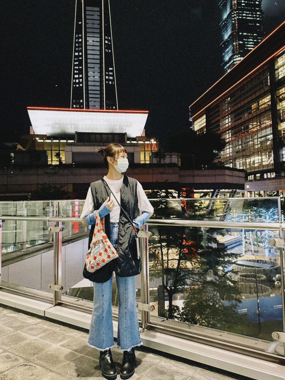 ブルー系のデニムパンツ、ホワイト系のTシャツ/カットソー、ブラック系のダウンベストを着用したレディースの秋コーディネートの2枚目の写真