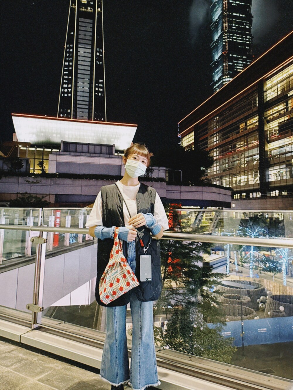 ブルー系のデニムパンツ、ホワイト系のTシャツ/カットソー、ブラック系のダウンベストを着用したレディースの秋コーディネートの3枚目の写真