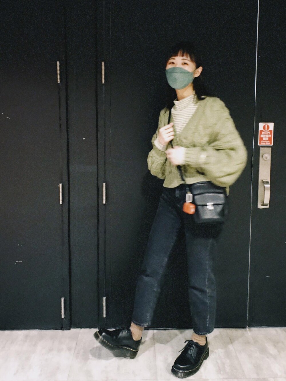 グレー系のデニムパンツ、グリーン系のブルゾン、ブラック系のシューズを着用したレディースの冬コーディネートの2枚目の写真