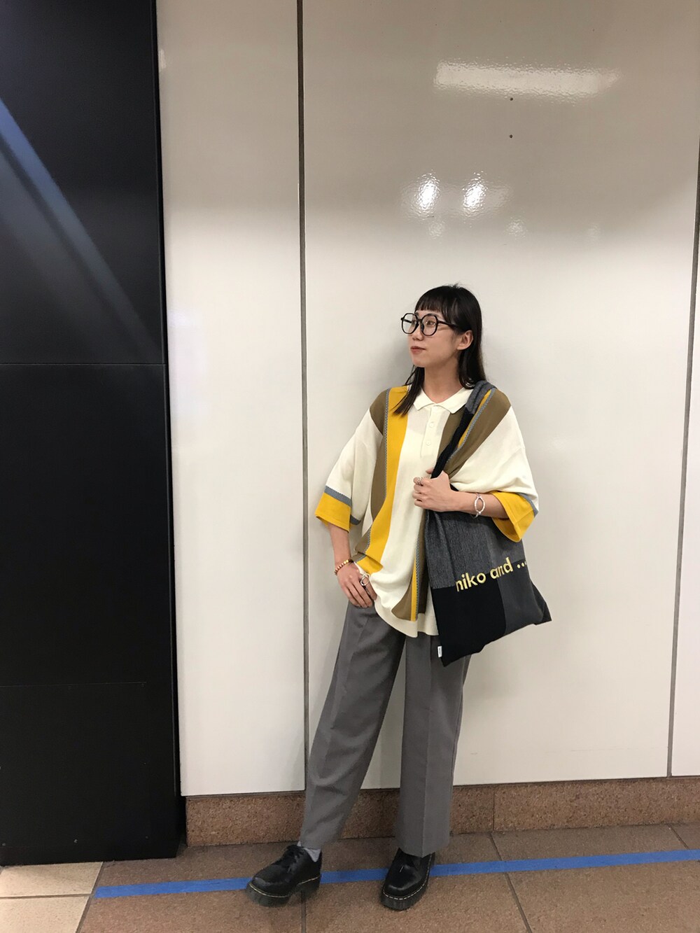 グレー系のスラックス、その他のポロシャツを着用したレディースの春コーディネートの3枚目の写真