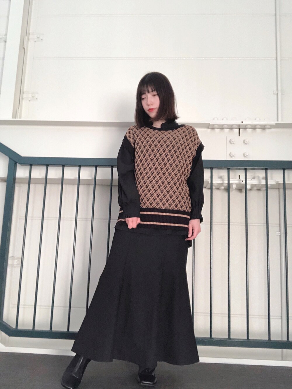 ブルー系のベスト、ブラック系のシャツ/ブラウス、ブラック系のスカートを着用したレディースの冬コーディネートの2枚目の写真