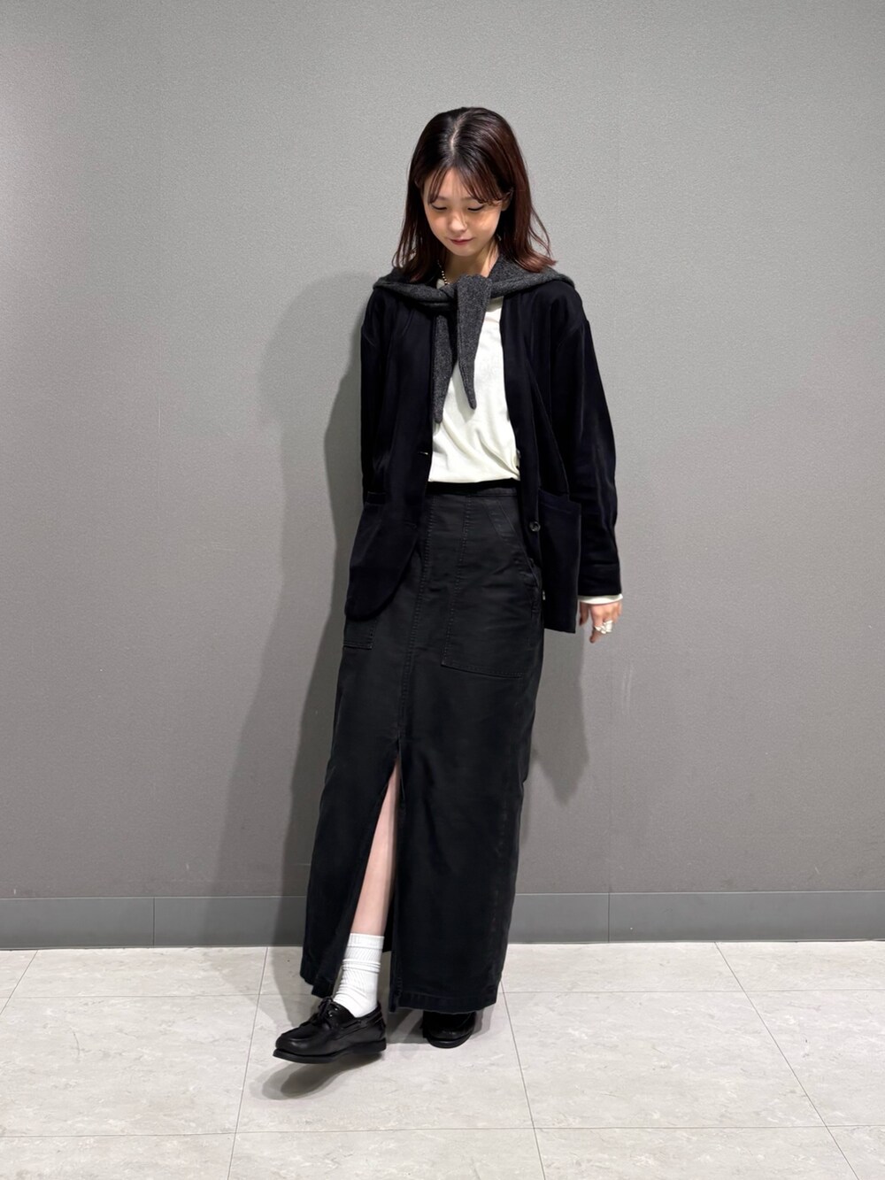 ブラック系のノーカラージャケット、グレー系のマフラーを着用したレディースの秋コーディネートの3枚目の写真