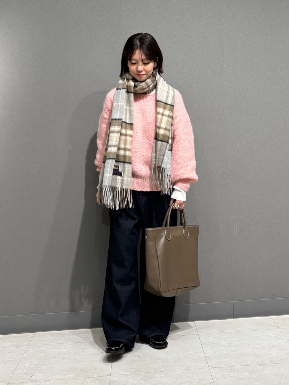 ピンク系のニット/セーター、ブルー系のデニムパンツ、ブラック系のローファーを着用したレディースの秋コーディネートの3枚目の写真