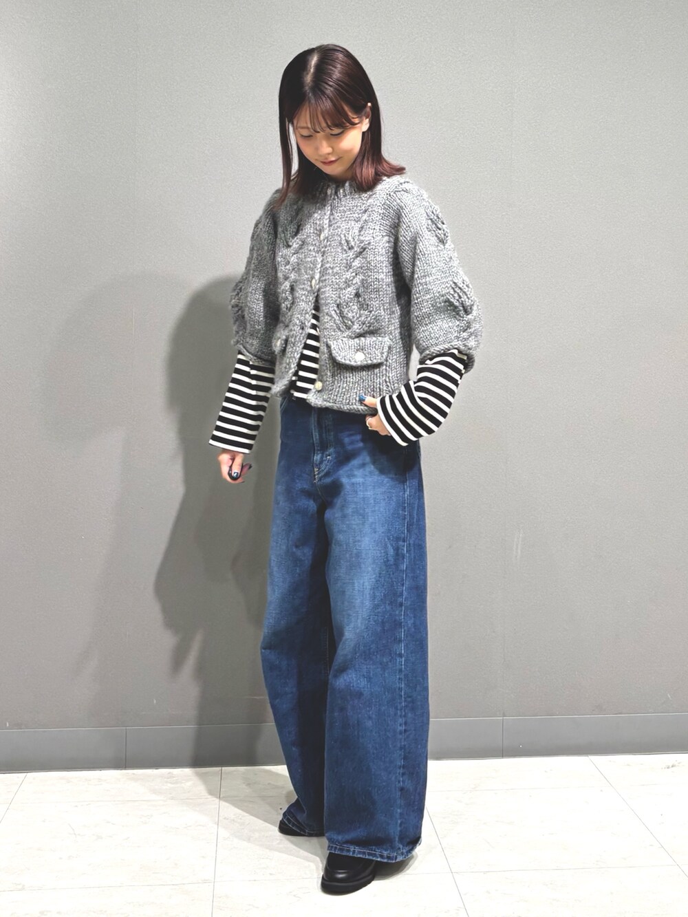 ブルー系のデニムパンツ、グレー系のカーディガン/ボレロ、ブラック系のTシャツ/カットソーを着用したレディースの秋コーディネートの4枚目の写真