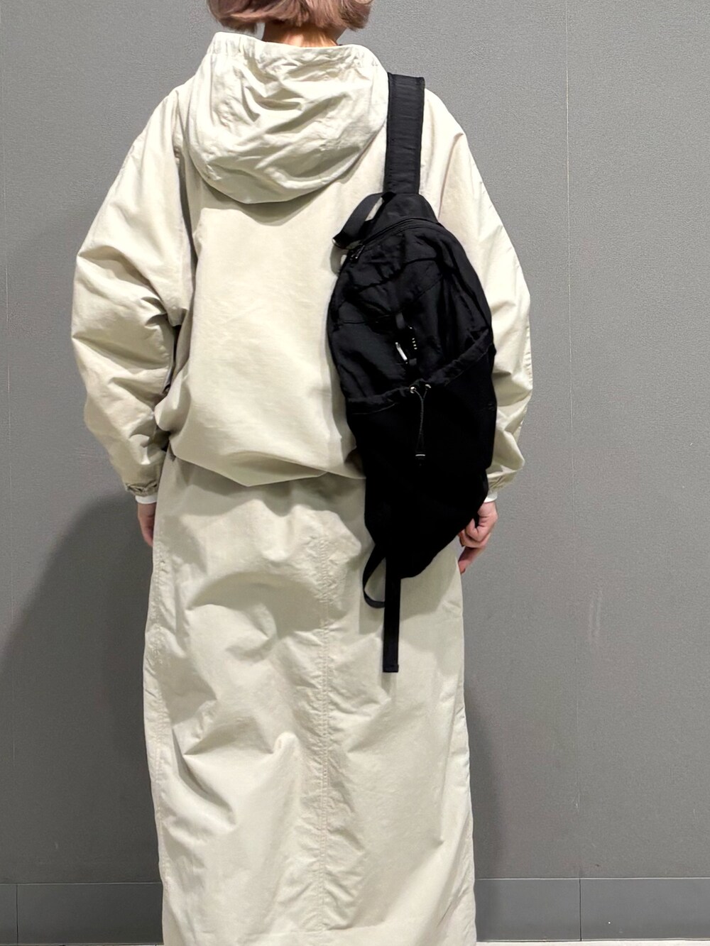 ベージュ系のスカート、ブルー系のデニムパンツ、ブラック系のバックパック/リュックを着用したレディースの冬コーディネートの5枚目の写真