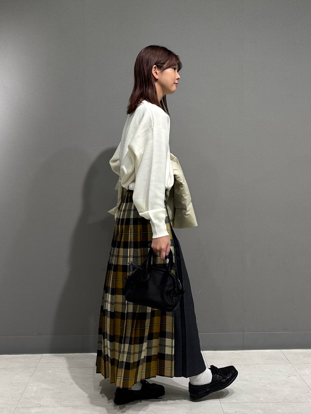 ホワイト系のダウンジャケット/コート、ホワイト系のニット/セーター、ベージュ系のスカートを着用したレディースの秋コーディネートの7枚目の写真