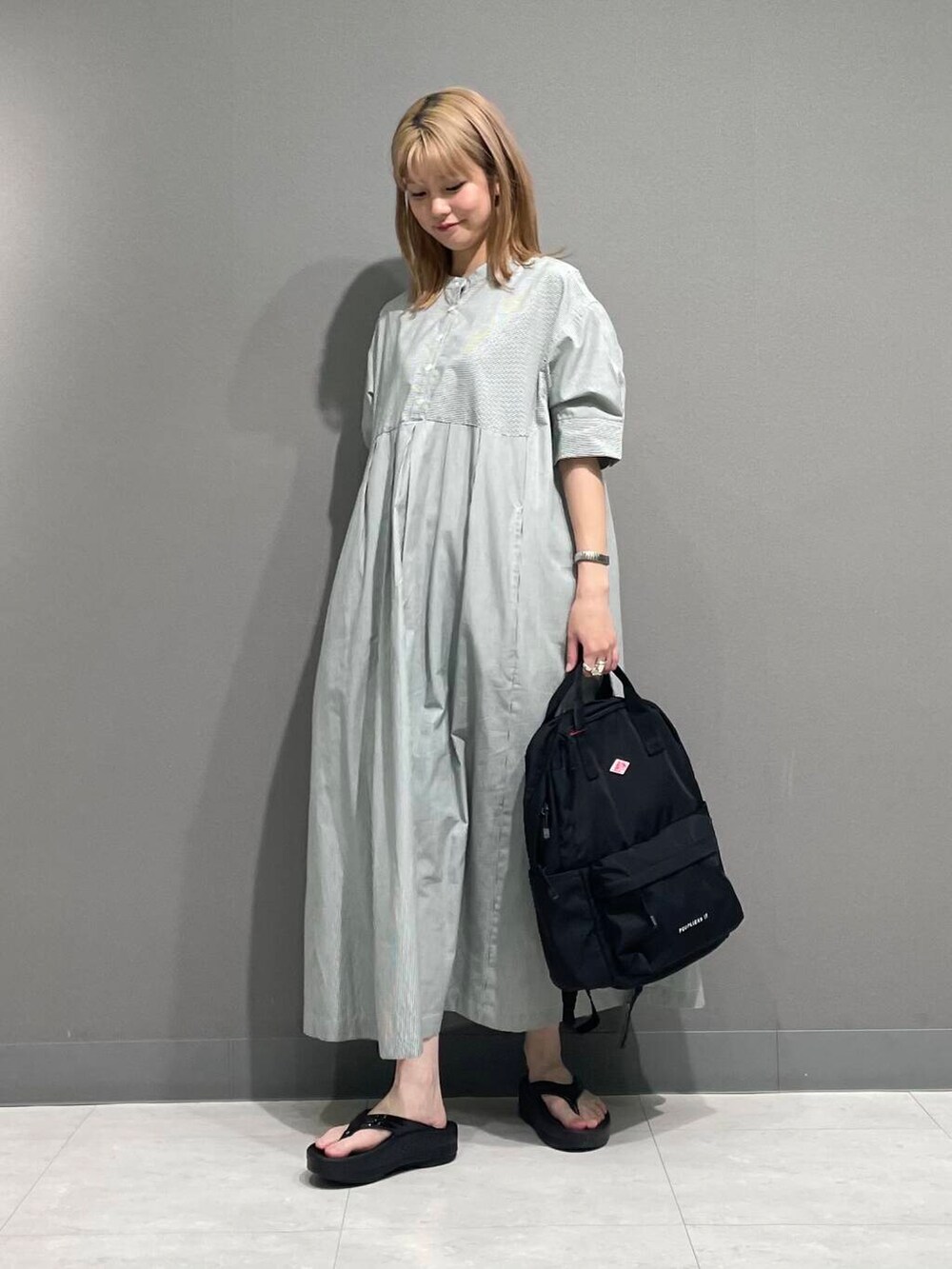 ブラック系のサンダル、グリーン系のワンピースを着用したレディースの夏コーディネートの5枚目の写真