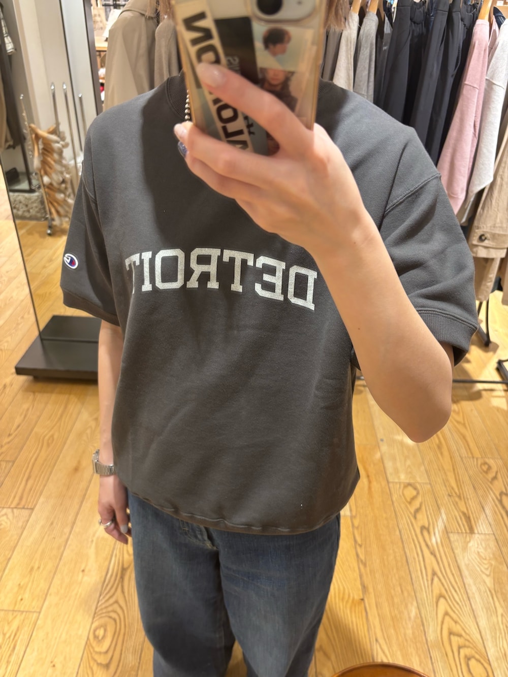 ブラック系のスウェット、ブルー系のデニムパンツを着用したレディースの春コーディネートの2枚目の写真
