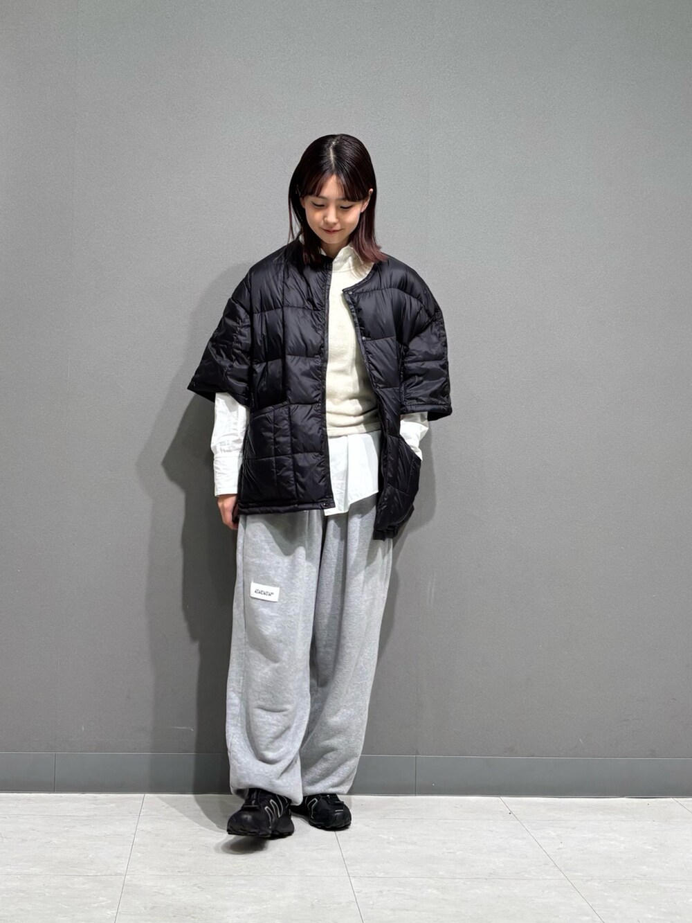 ブラック系のダウンジャケット/コート、グレー系のスウェットパンツを着用したレディースの秋コーディネートの6枚目の写真