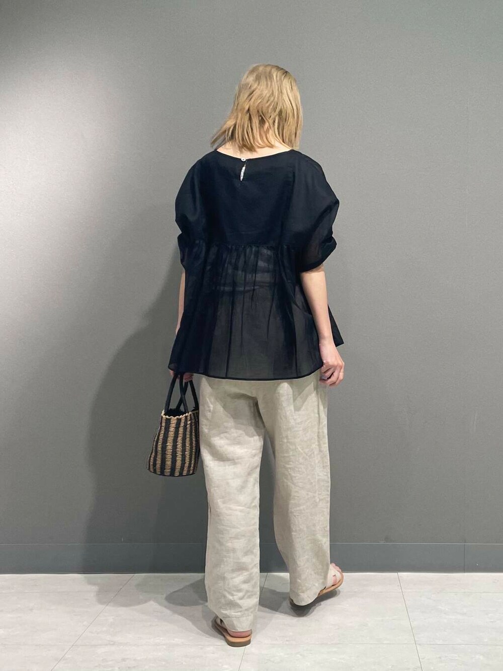 ベージュ系のその他パンツ、ブラック系のハンドバッグ、ブラック系のシャツ/ブラウスを着用したレディースの春コーディネートの4枚目の写真