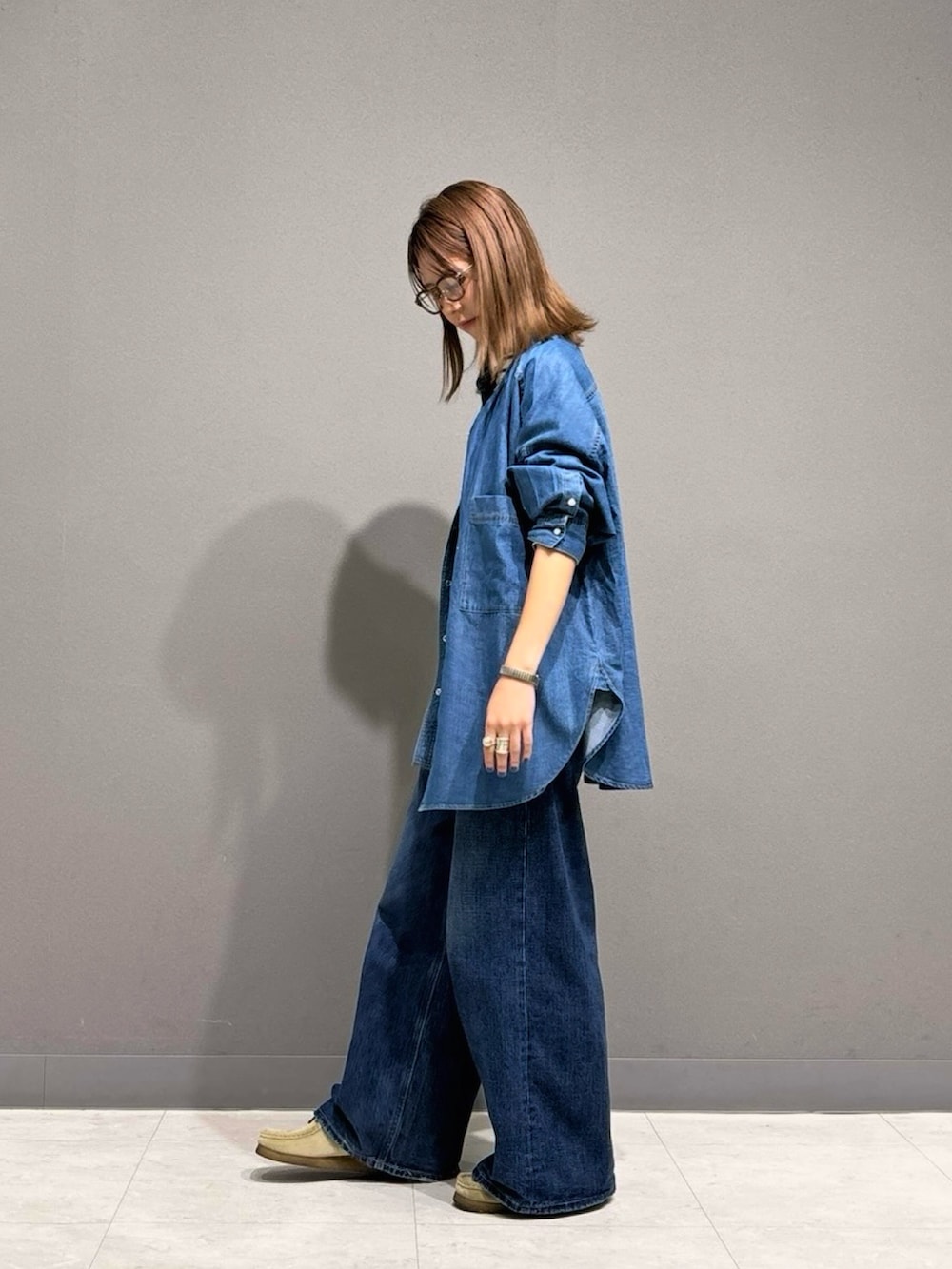 ブルー系のシャツ/ブラウス、ブラック系のTシャツ/カットソー、ブラック系のハンドバッグを着用したレディースの秋コーディネートの2枚目の写真