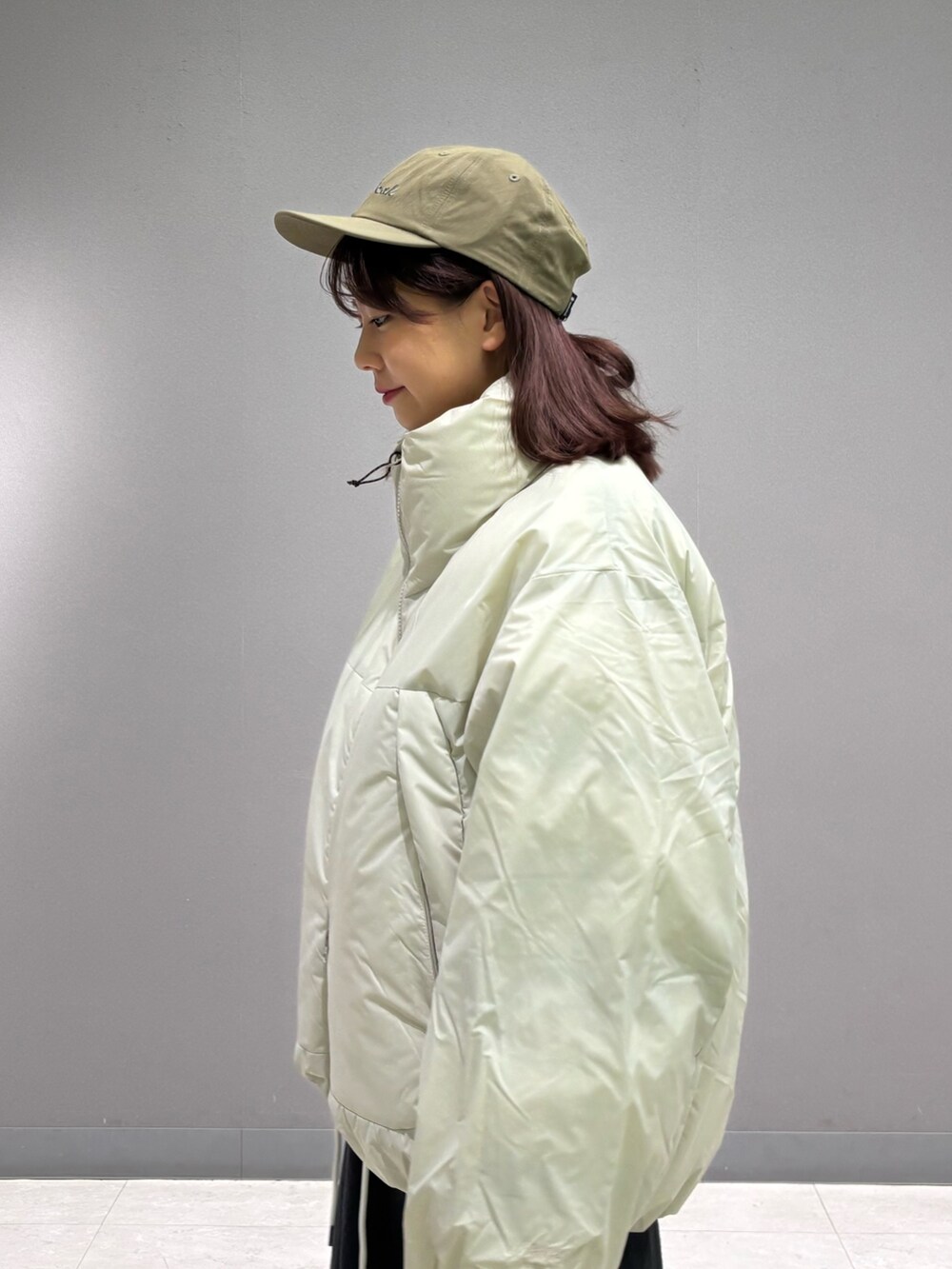 ホワイト系のダウンジャケット/コート、グリーン系のキャップを着用したレディースの秋コーディネートの5枚目の写真