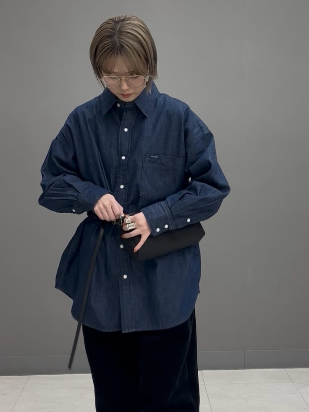 ブラック系のショルダーバッグ、ブルー系のシャツ/ブラウスを着用したレディースの冬コーディネートの6枚目の写真