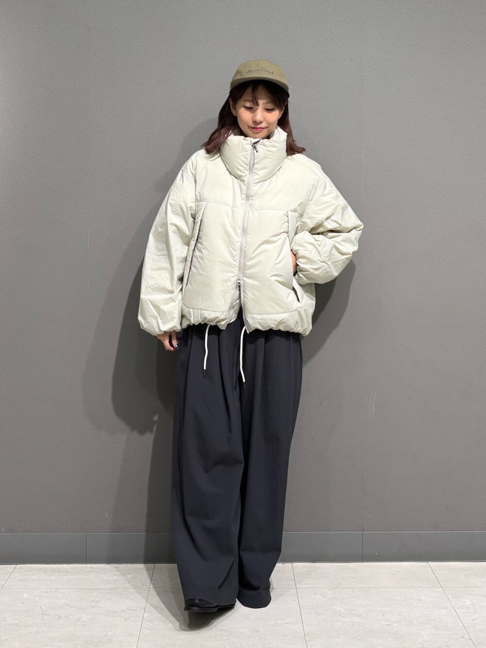 ホワイト系のダウンジャケット/コート、グリーン系のキャップを着用したレディースの秋コーディネートの2枚目の写真