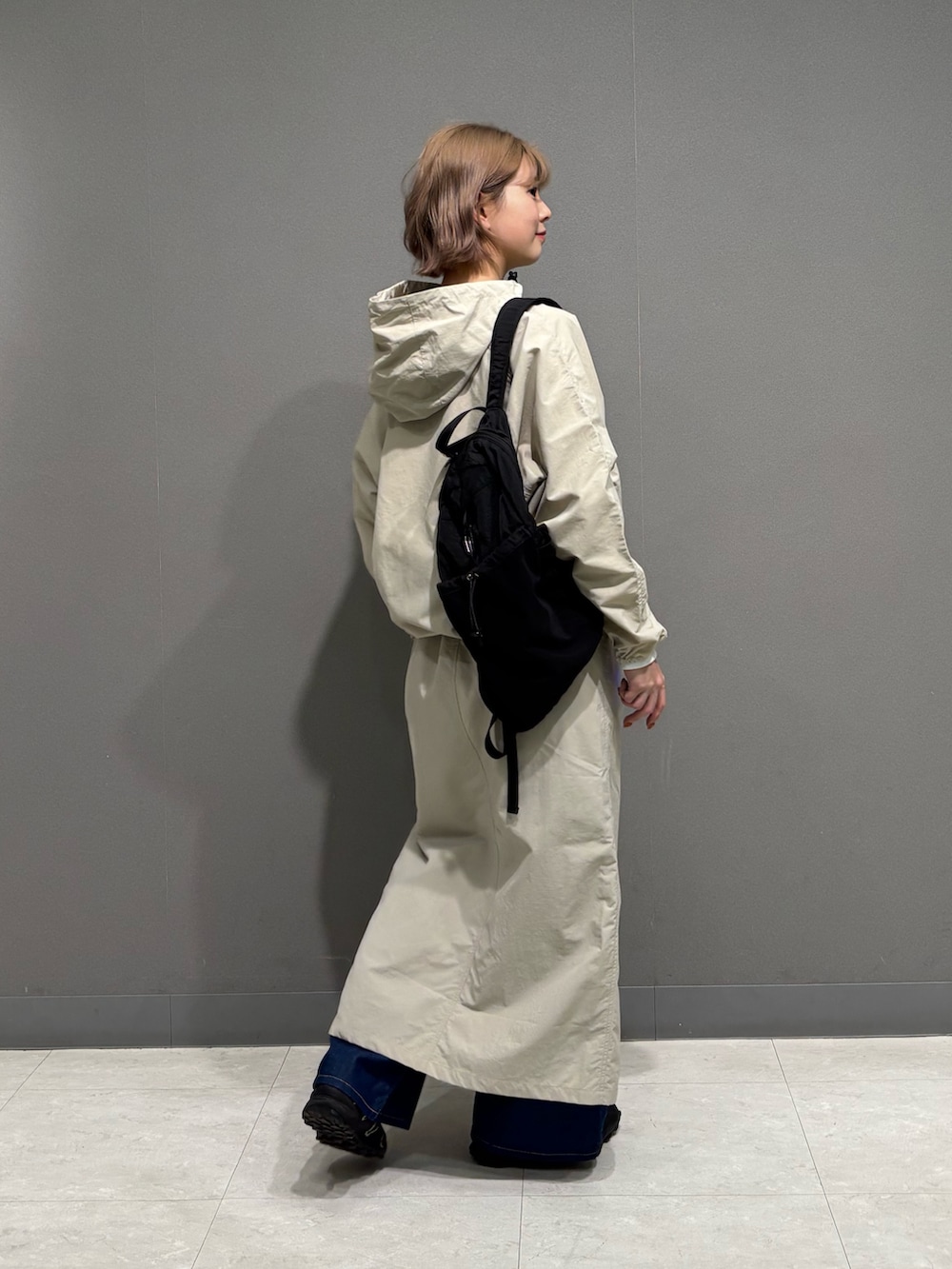 ベージュ系のスカート、ブルー系のデニムパンツ、ブラック系のバックパック/リュックを着用したレディースの冬コーディネートの4枚目の写真