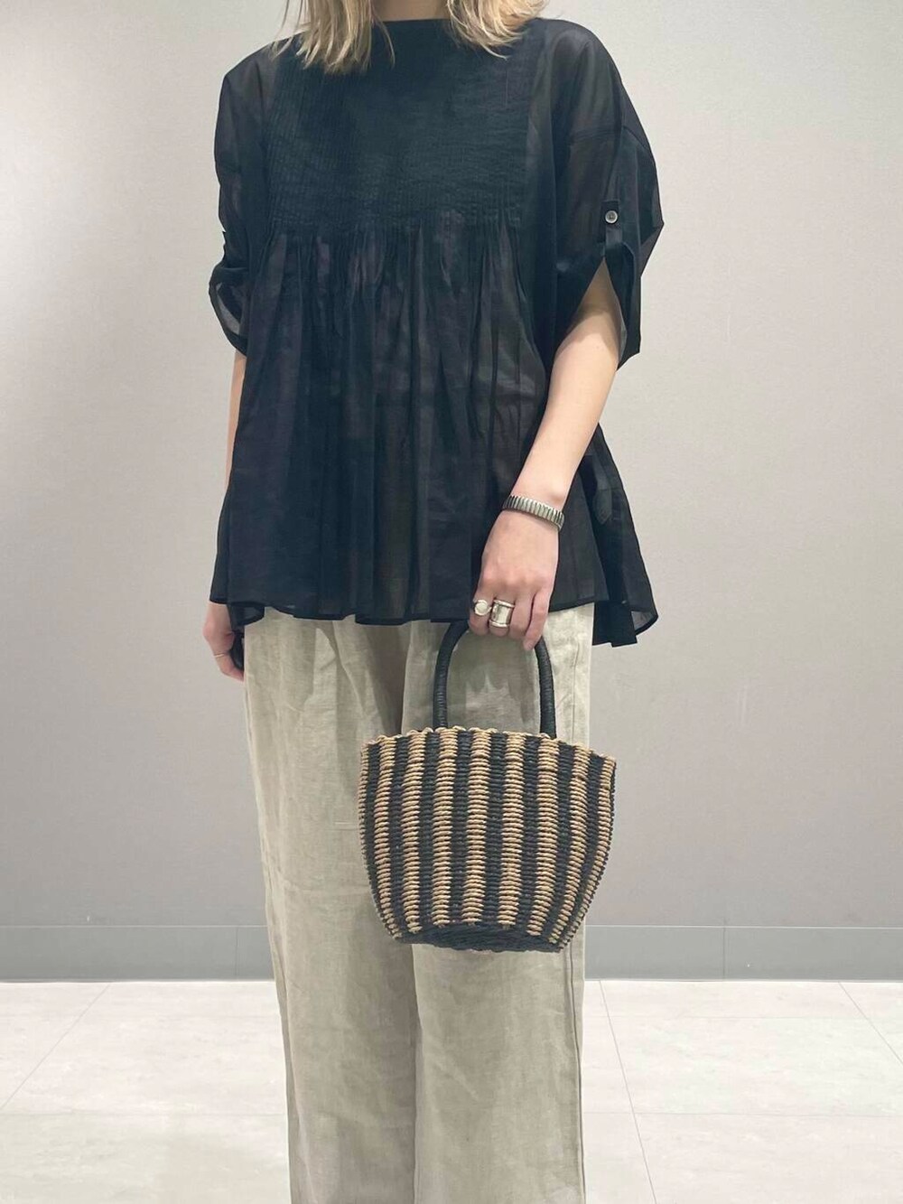 ベージュ系のその他パンツ、ブラック系のハンドバッグ、ブラック系のシャツ/ブラウスを着用したレディースの春コーディネートの7枚目の写真