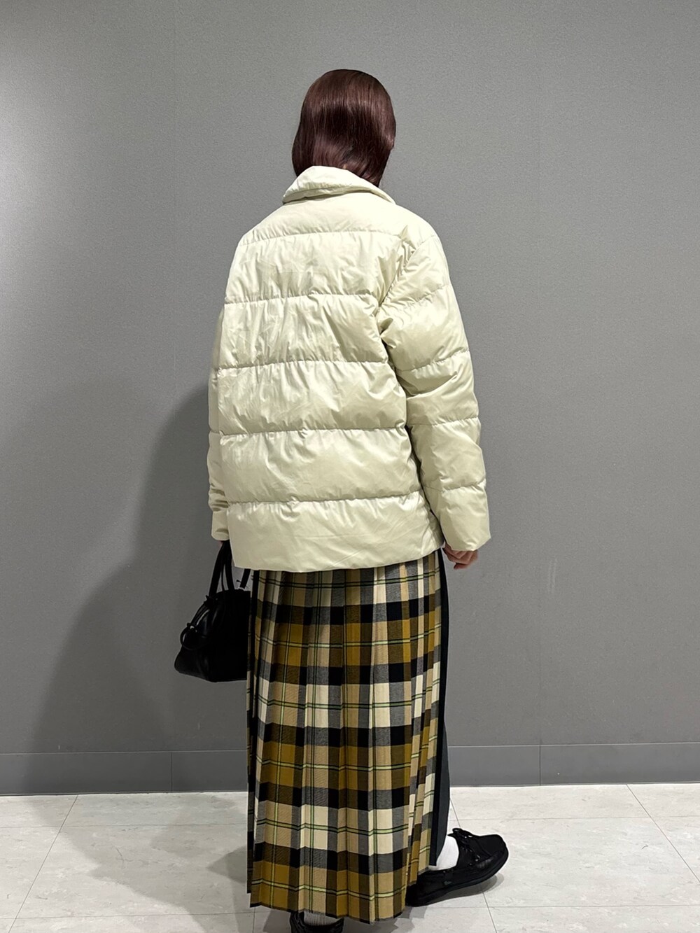 ホワイト系のダウンジャケット/コート、ホワイト系のニット/セーター、ベージュ系のスカートを着用したレディースの秋コーディネートの5枚目の写真