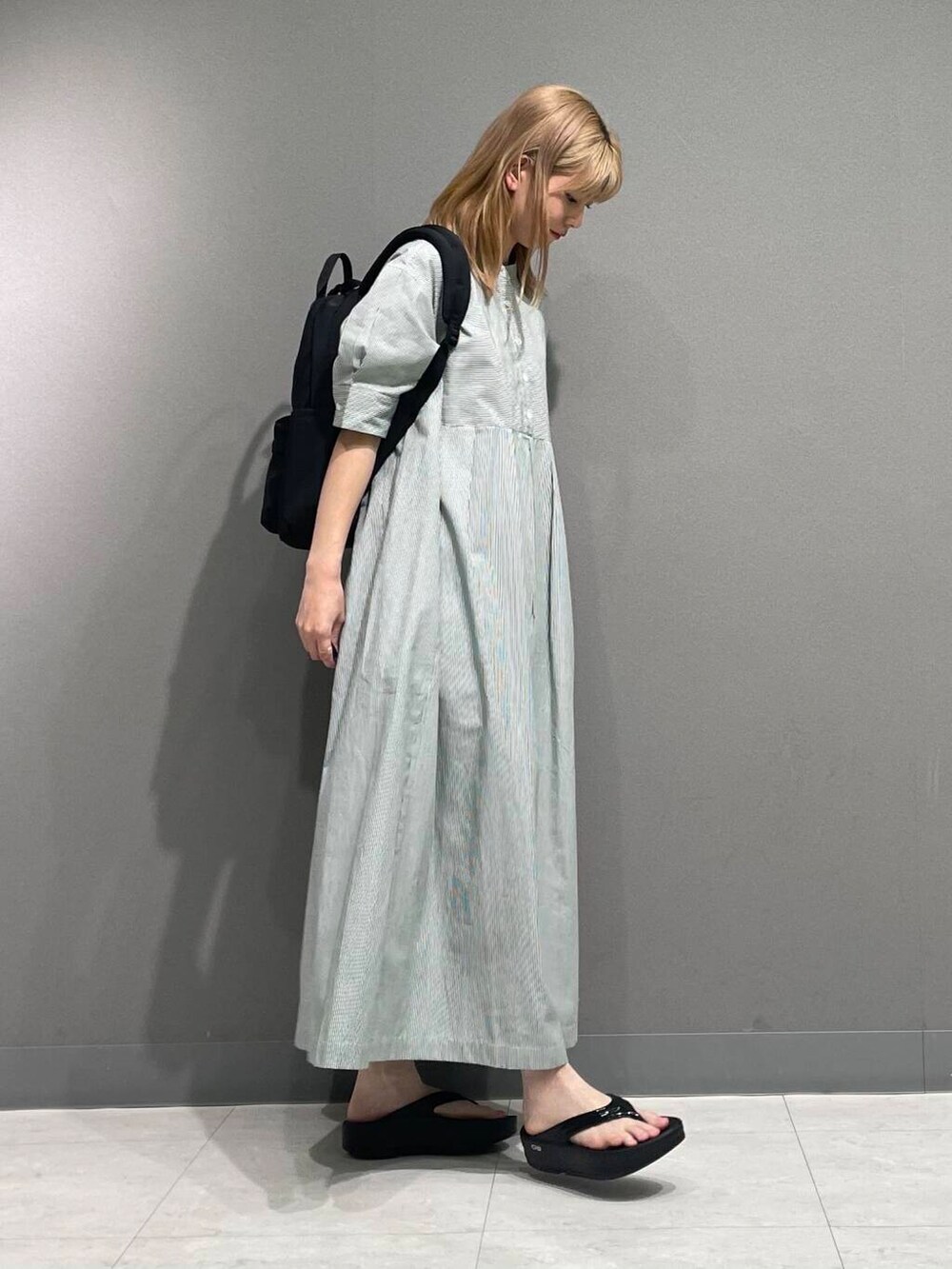 ブラック系のサンダル、グリーン系のワンピースを着用したレディースの夏コーディネートの3枚目の写真