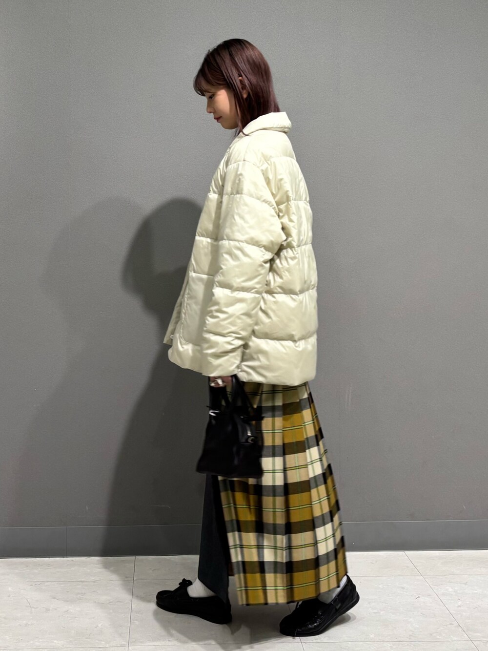 ホワイト系のダウンジャケット/コート、ホワイト系のニット/セーター、ベージュ系のスカートを着用したレディースの秋コーディネートの4枚目の写真