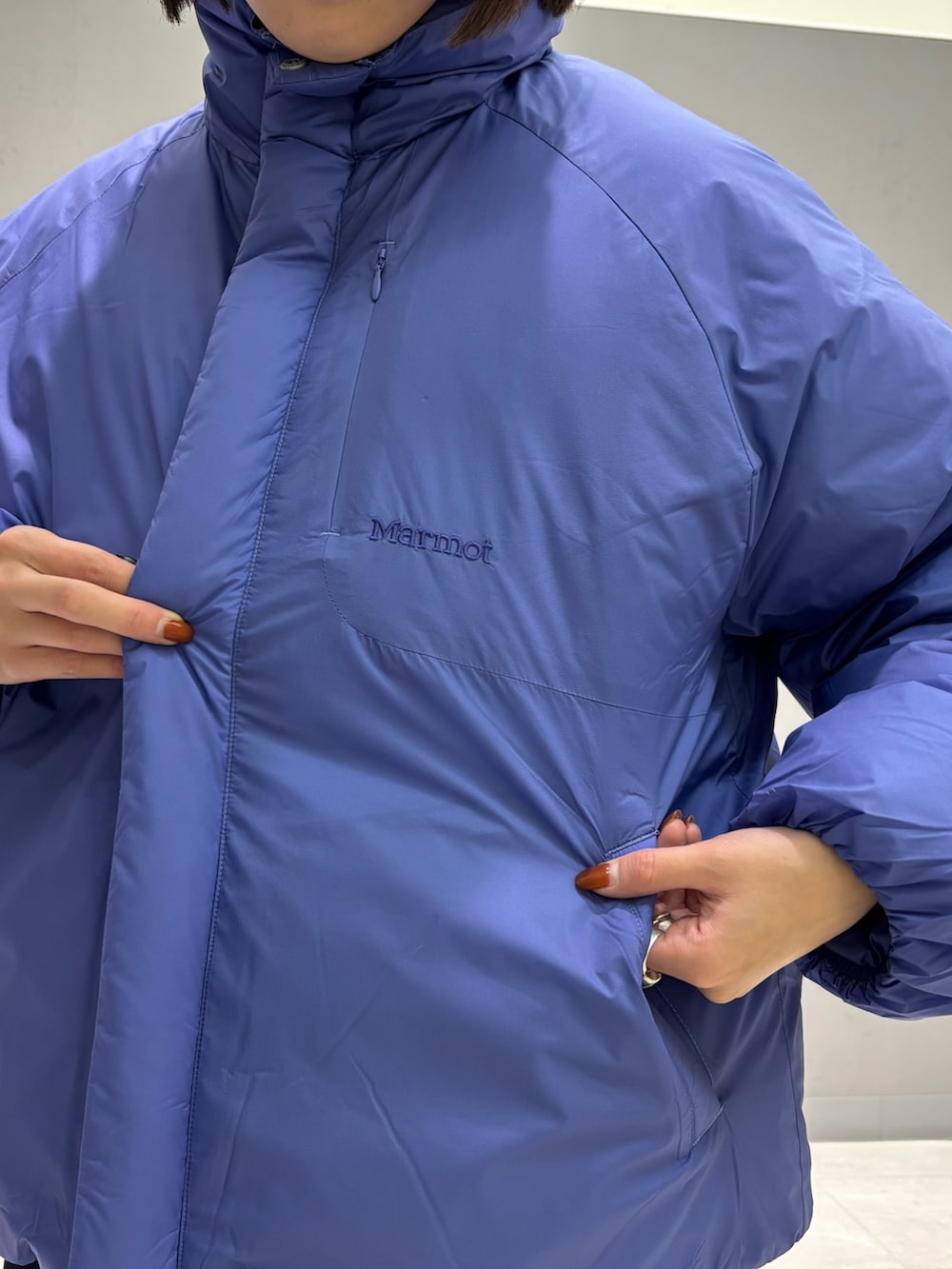 パープル系のダウンジャケット/コート、ブルー系のデニムパンツ、ベージュ系のサンダルを着用したレディースの秋コーディネートの3枚目の写真