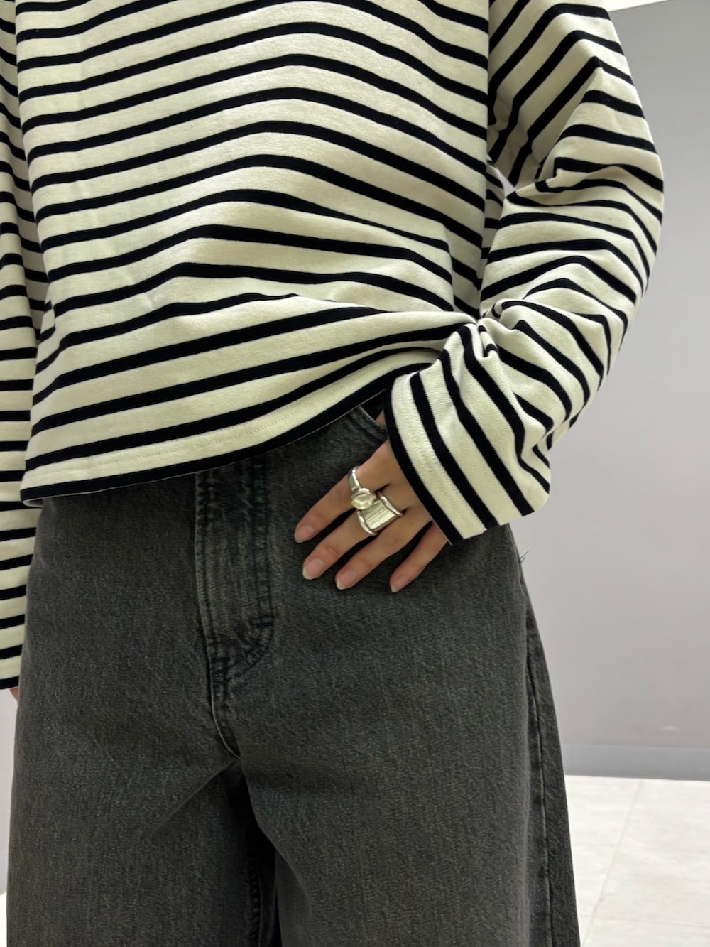 ホワイト系のTシャツ/カットソー、ベージュ系のステンカラーコート、ブラック系のトートバッグを着用したレディースの秋コーディネートの4枚目の写真