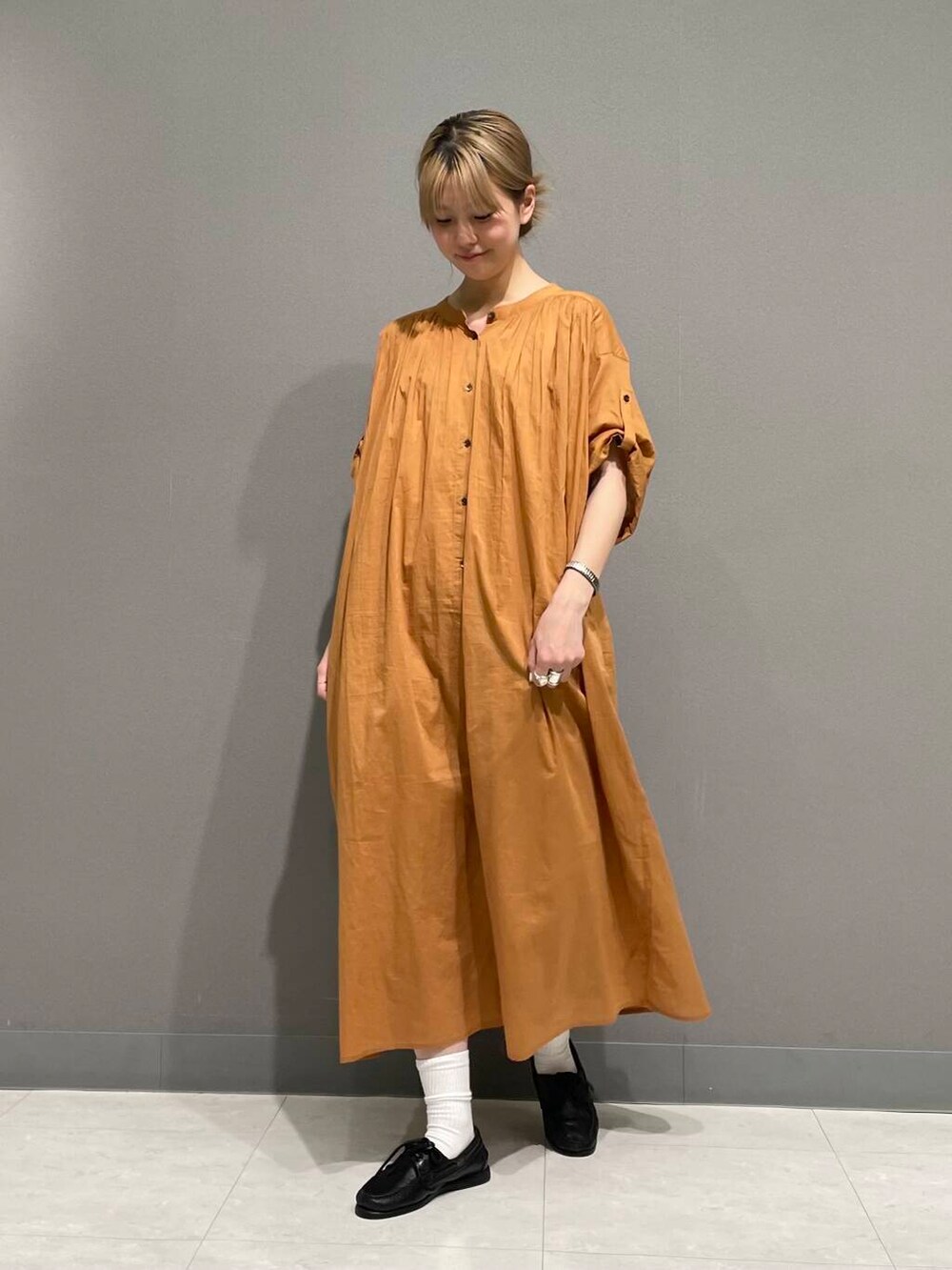 オレンジ系のワンピースを着用したレディースの春コーディネートの2枚目の写真