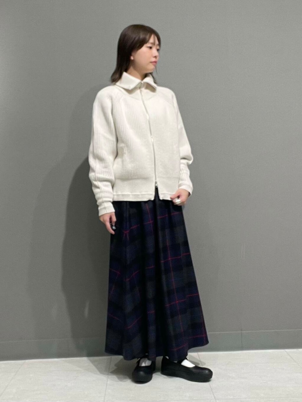 ホワイト系のカーディガン/ボレロ、グレー系のTシャツ/カットソー、ブルー系のスカートを着用したレディースの秋コーディネートの2枚目の写真