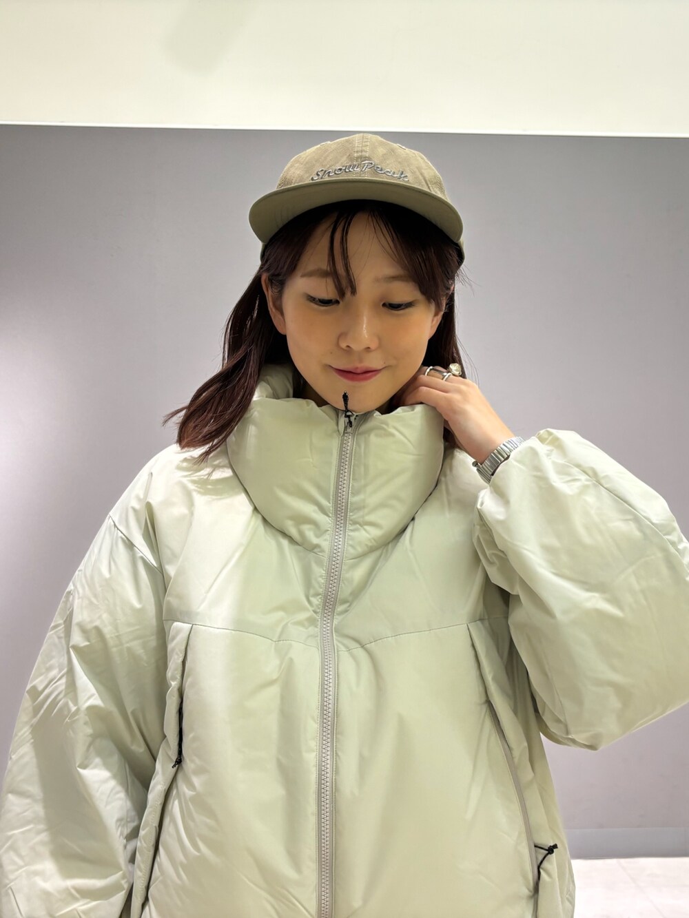 ホワイト系のダウンジャケット/コート、グリーン系のキャップを着用したレディースの秋コーディネートの7枚目の写真