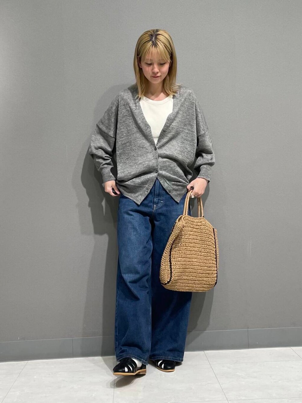 グレー系のカーディガン/ボレロ、ブラック系のサンダル、ベージュ系のトートバッグを着用したレディースの春コーディネートの2枚目の写真