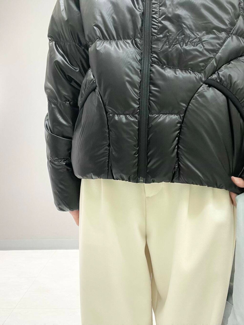 ホワイト系のその他パンツ、ブルー系のTシャツ/カットソー、ブラック系のダウンジャケット/コートを着用したレディースの冬コーディネートの5枚目の写真