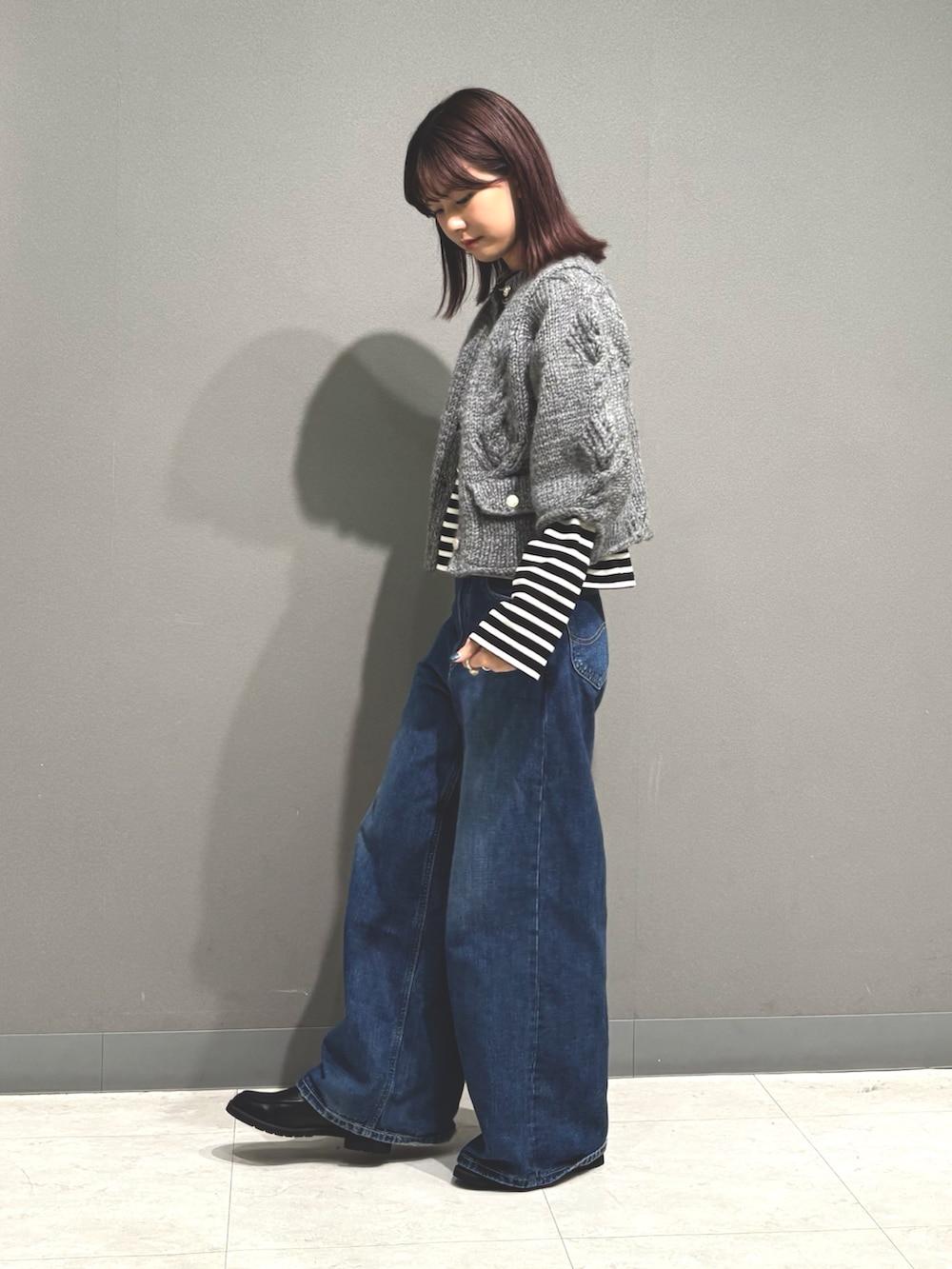 ブルー系のデニムパンツ、グレー系のカーディガン/ボレロ、ブラック系のTシャツ/カットソーを着用したレディースの秋コーディネートの5枚目の写真