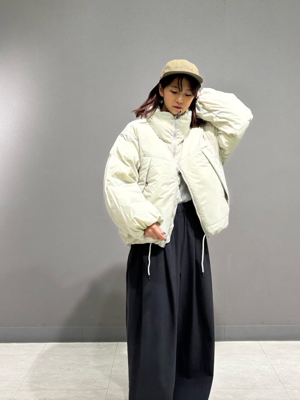 ホワイト系のダウンジャケット/コート、グリーン系のキャップを着用したレディースの秋コーディネートの4枚目の写真