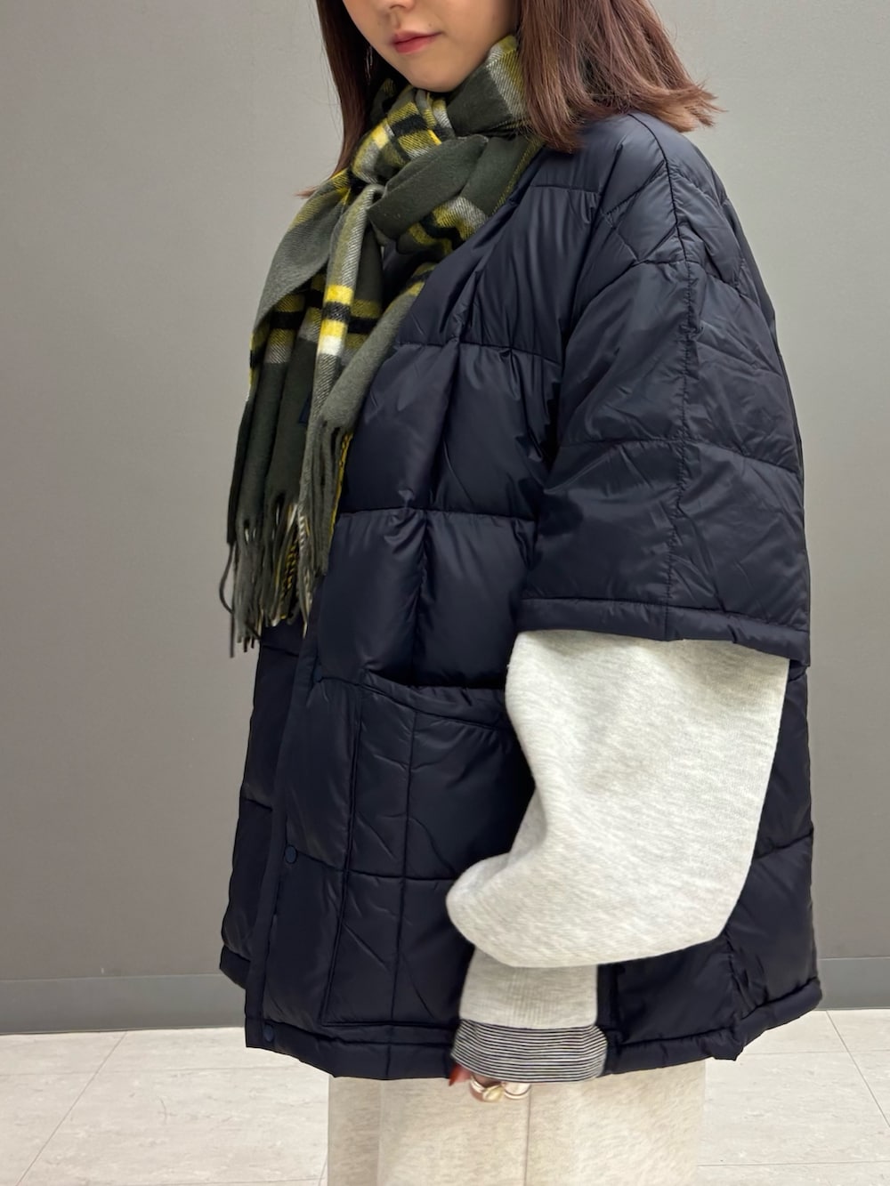 ベージュ系のその他パンツ、グレー系のニット/セーター、ブルー系のダウンジャケット/コートを着用したレディースの秋コーディネートの5枚目の写真