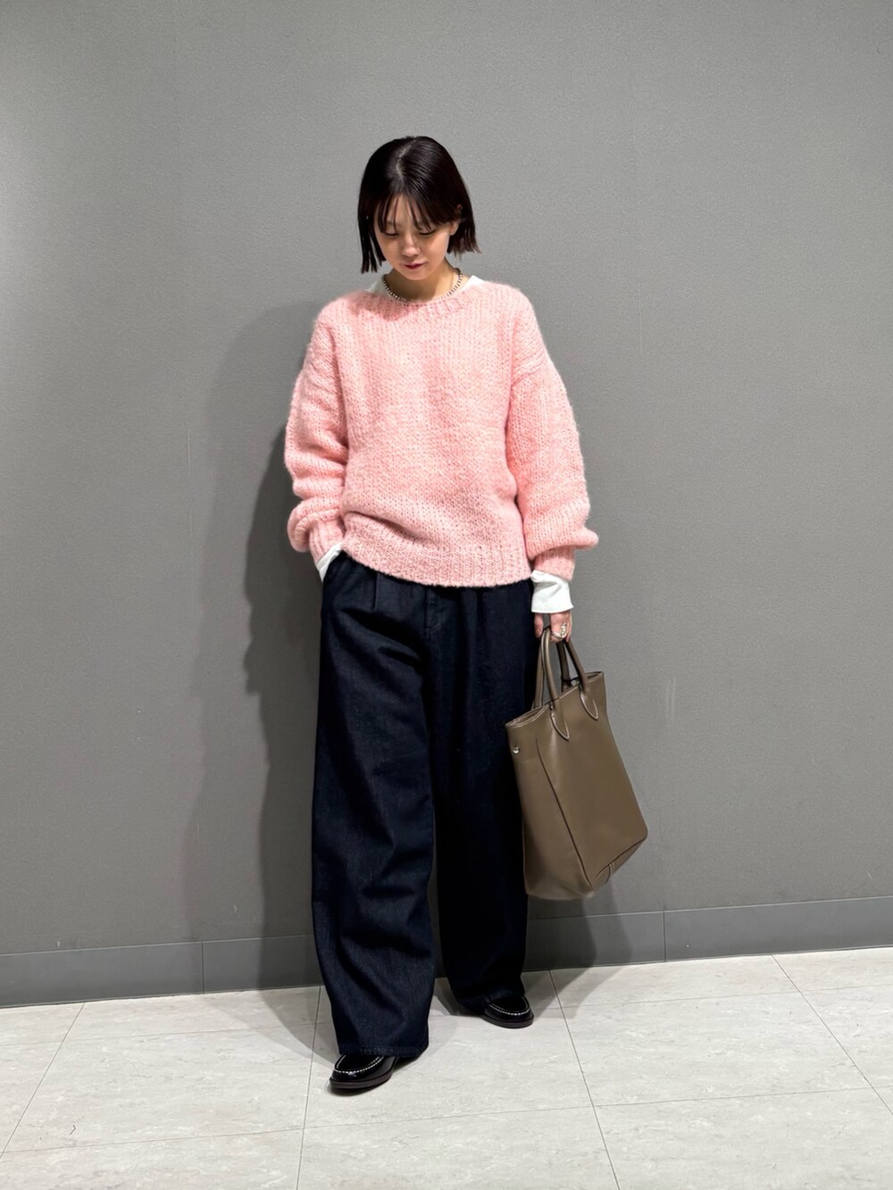 ピンク系のニット/セーター、ブルー系のデニムパンツ、ブラック系のローファーを着用したレディースの秋コーディネートの2枚目の写真